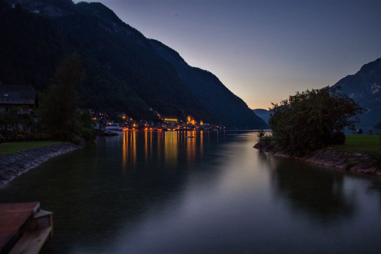 peaceful evening view of hallstatt lake with illuminated lights reflec