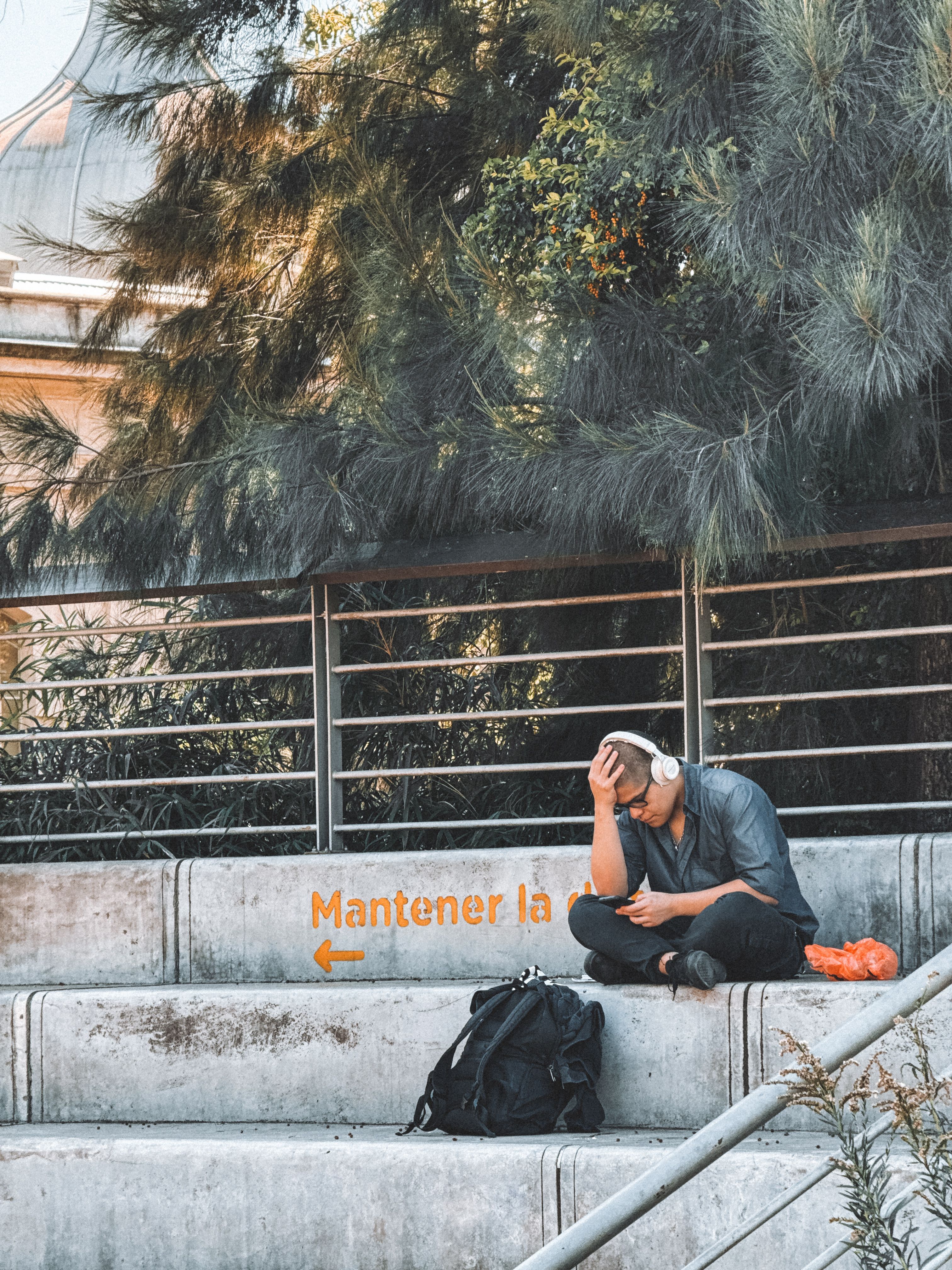 A man listens to music with headphones on concrete steps in Buenos Aires, Argentina.