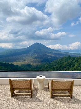 Enjoy a serene mountain view from a cozy patio with empty chairs.