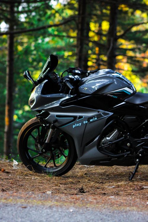 Free A modern sports motorcycle parked in an autumn forest setting. Stock Photo