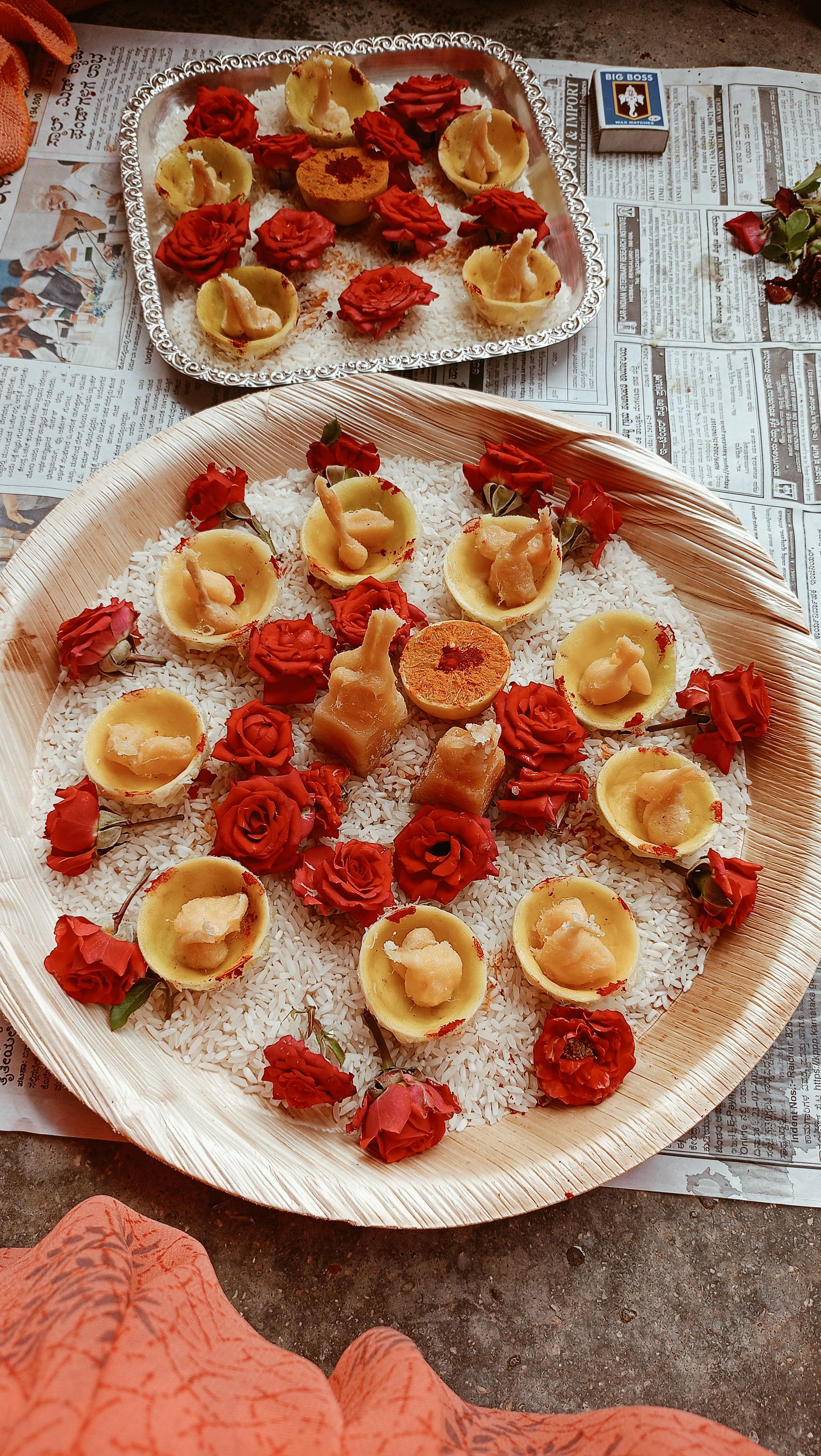 Elegant display of festive food and roses on rice, set on decorative platters for a cultural ceremony.