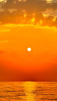 Stunning sunrise over ocean with golden sky and sun reflecting on water. Ideal for travel and nature themes.