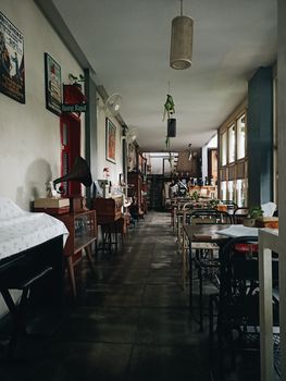 Charming vintage café interior in Medan, Indonesia, featuring antique decor and retro style furniture.