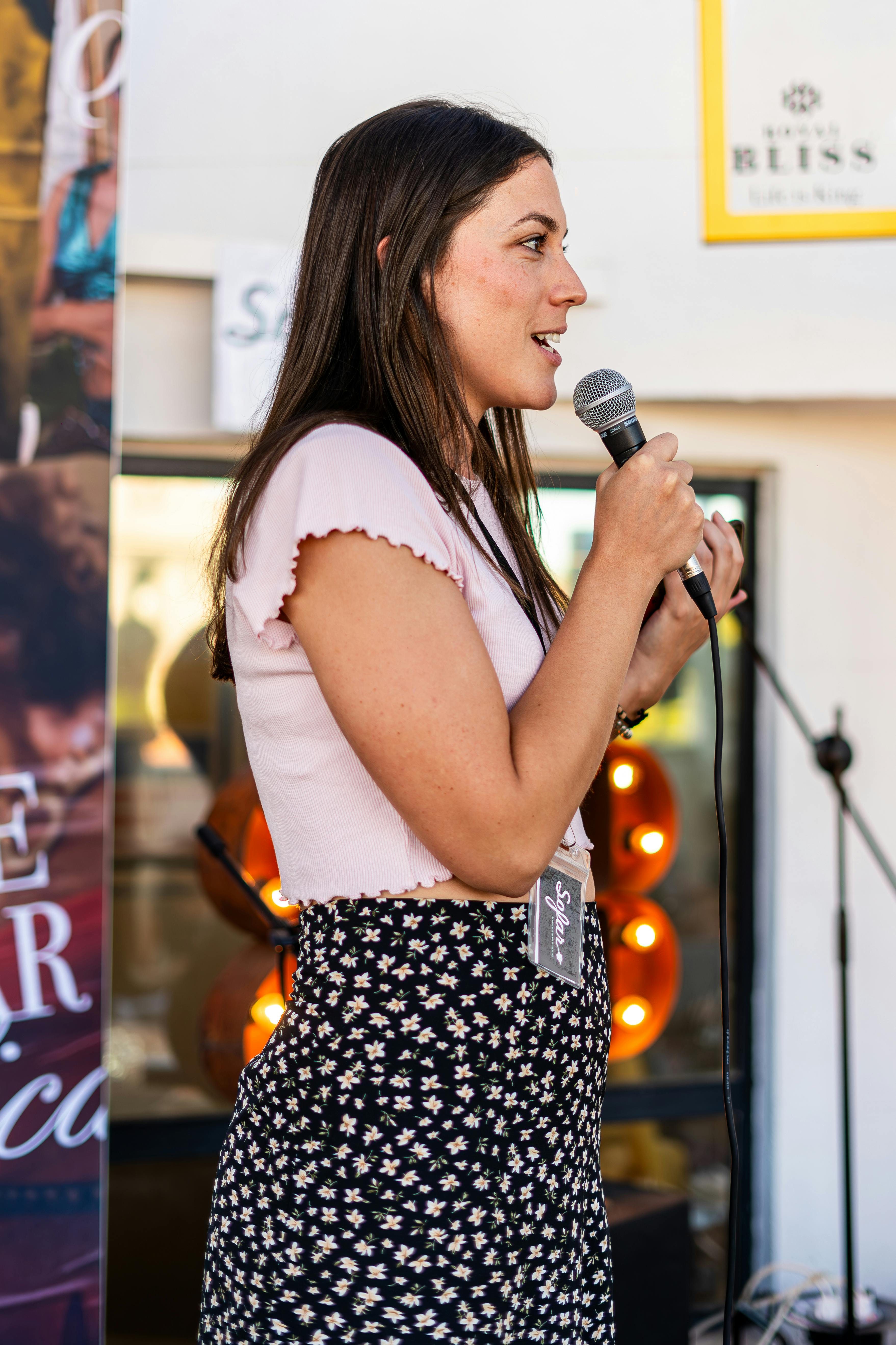 a woman is holding a microphone and speaking