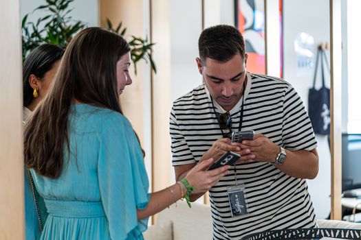 Three people sharing a fun moment using smartphones indoors, creating connections.