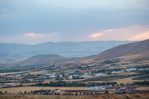 Free A serene view of Elazig's countryside with hills and fields under a pastel sky at dusk. Stock Photo