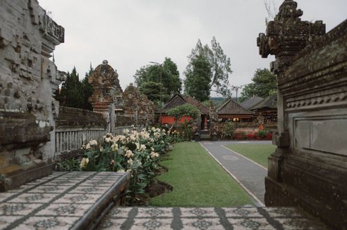 Free Explore the tranquil beauty of a traditional Balinese temple garden with lush greenery and ancient architecture. Stock Photo