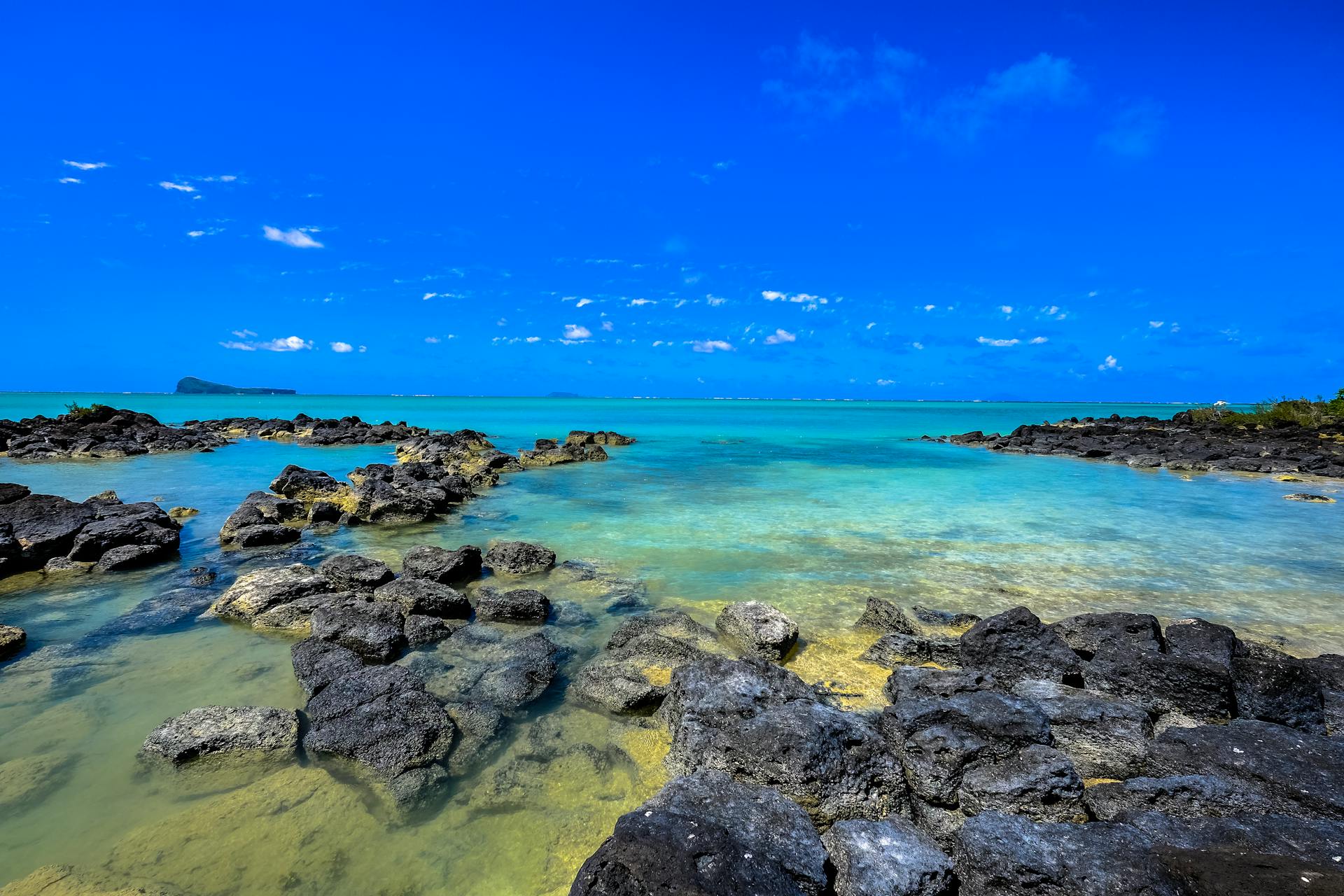 Beautiful coastal scene in Mauritius with clear turquoise waters and rocky shores.