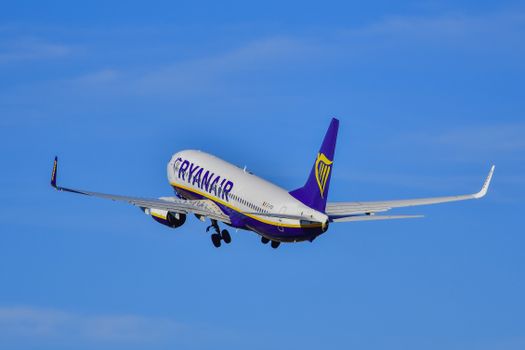 A Ryanair airplane ascends into a cloudless sky, showcasing aviation and travel excitement.
