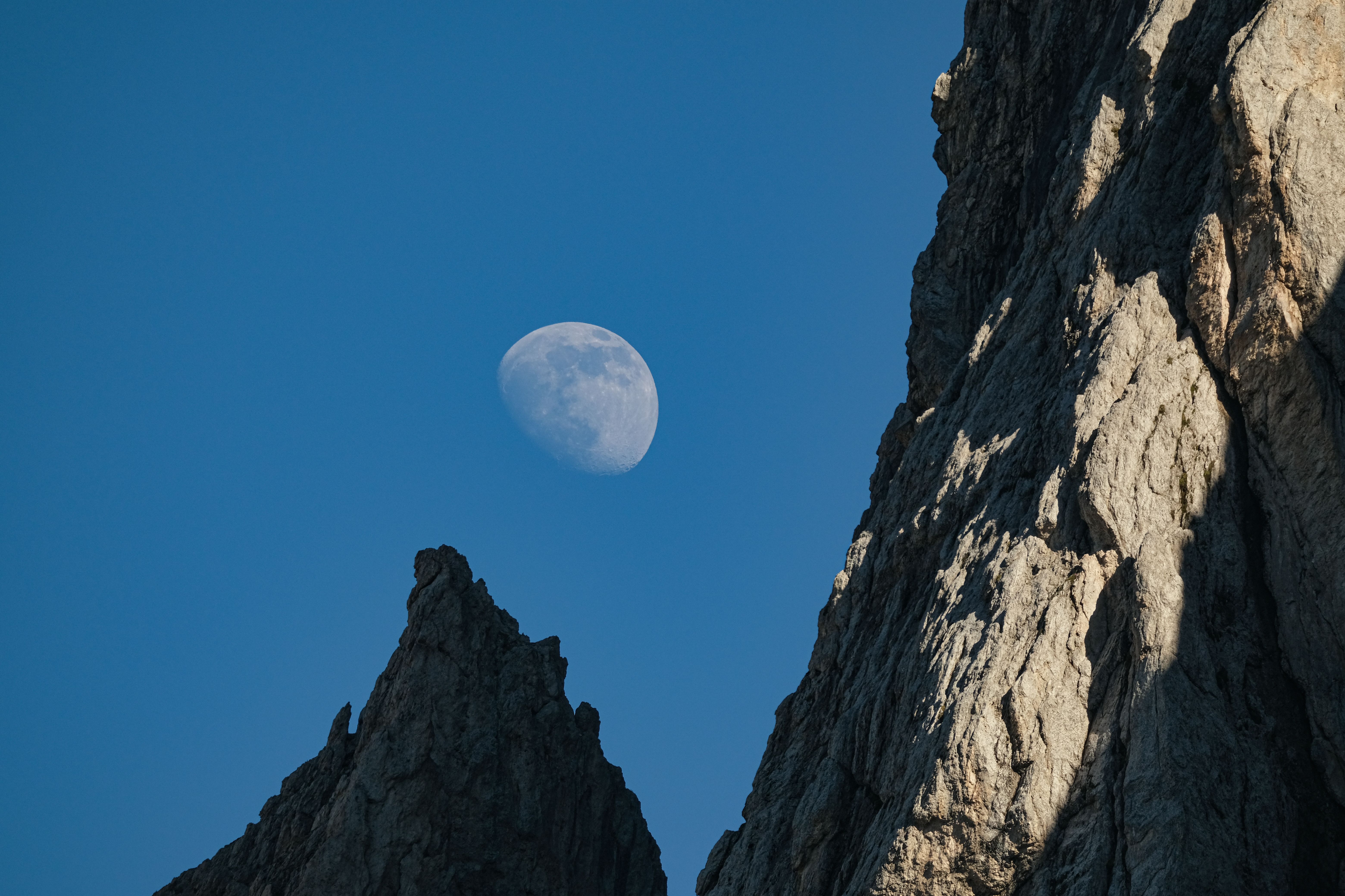 The moon is seen above the rocks in the sky · Free Stock Photo