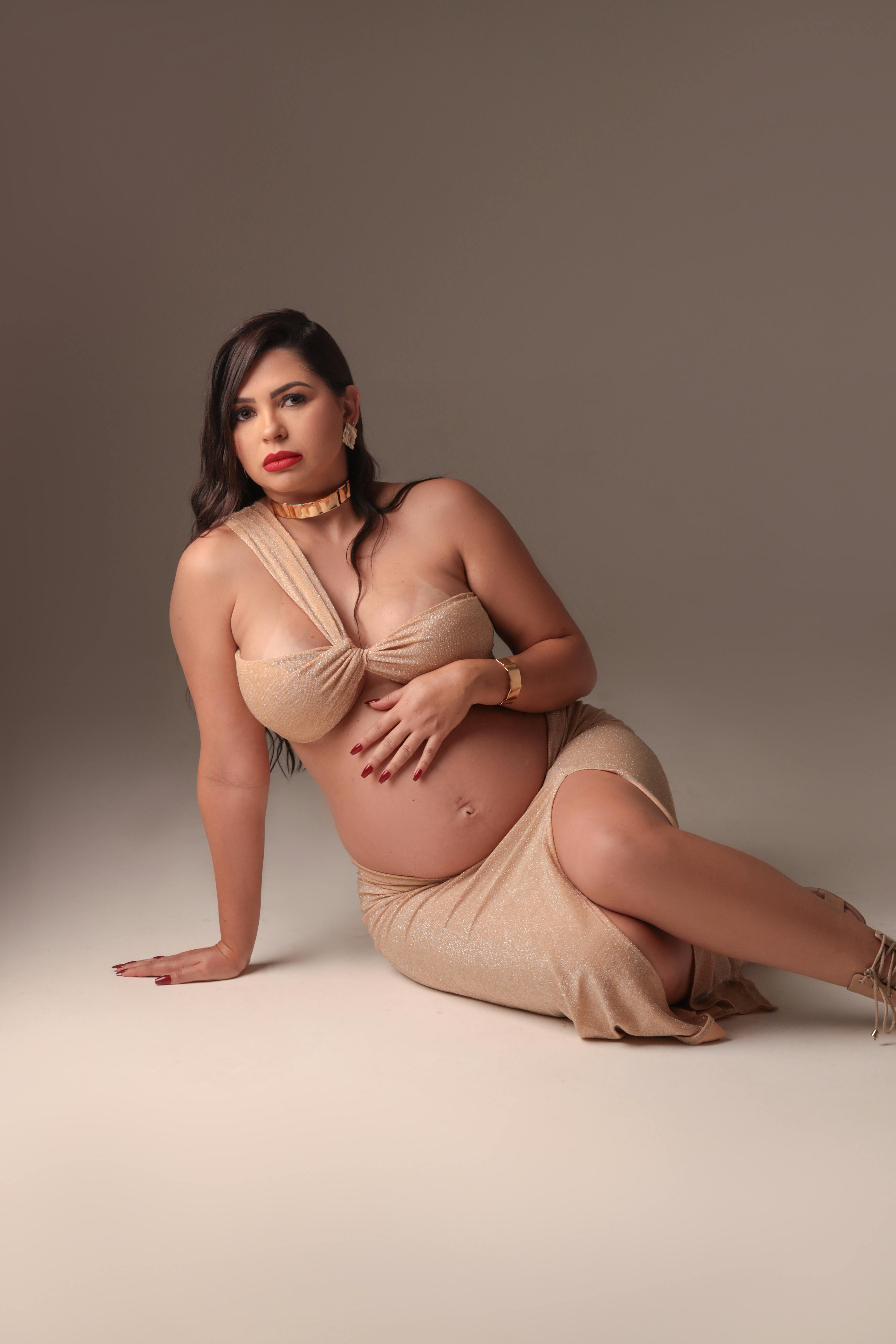 pregnant woman in a beige bra and skirt