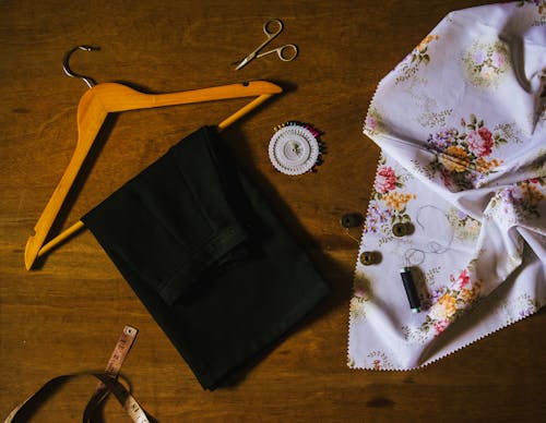 Черный текстиль на коричневой деревянной вешалке для одежды