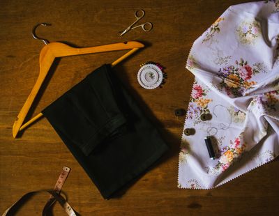 Cut fabric and a hanger on a wooden bench — photo by Riya Kumari on Pexels