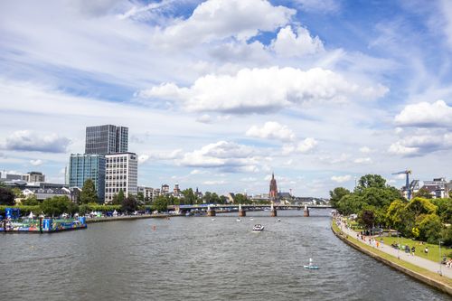 Free A vibrant cityscape of Frankfurt with the Main River under a blue sky, showcasing modern and historic architecture. Stock Photo