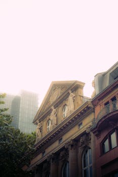 An elegant blend of classical architecture and modern skyline captured in daylight.