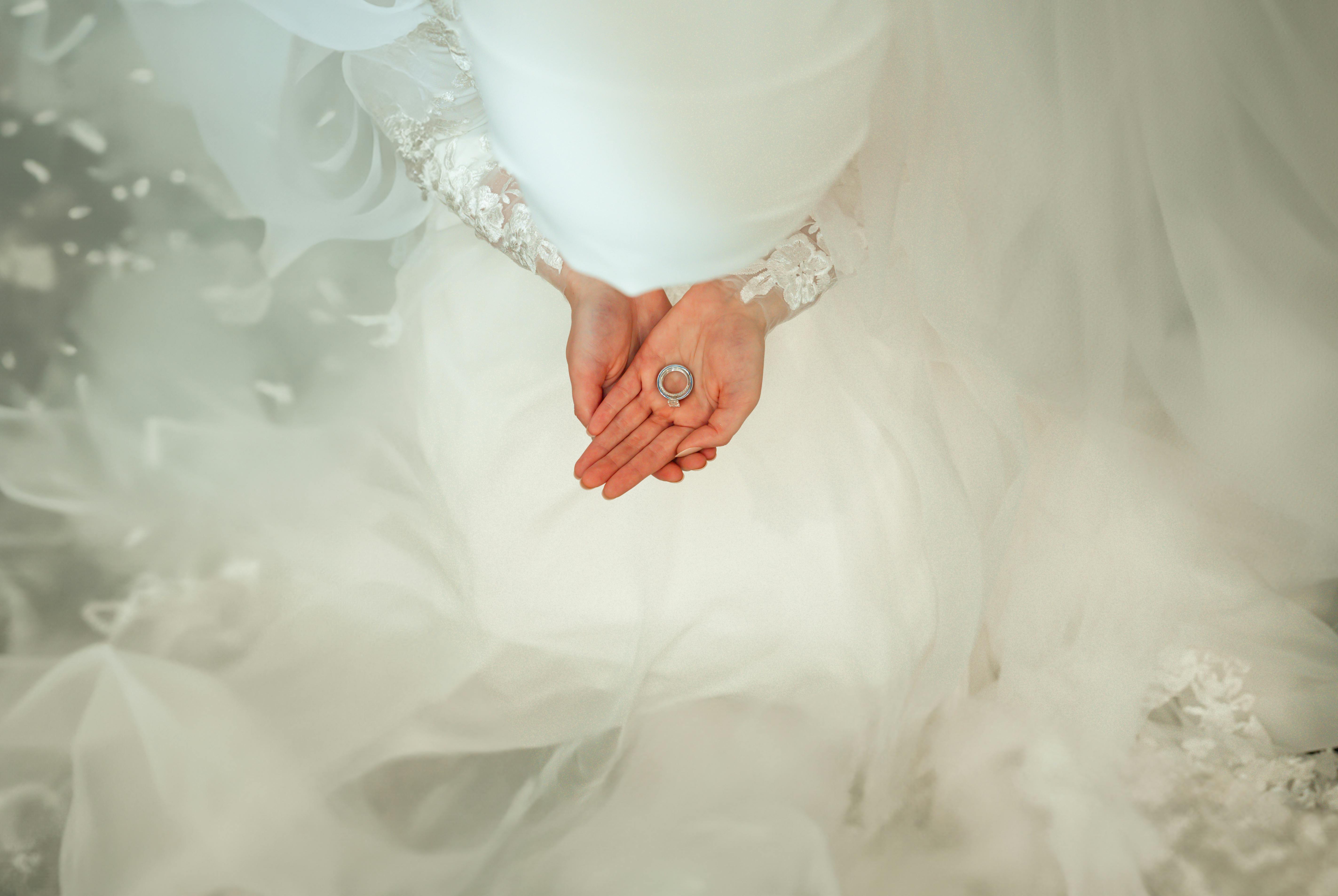 a bride holding her wedding ring in her hands