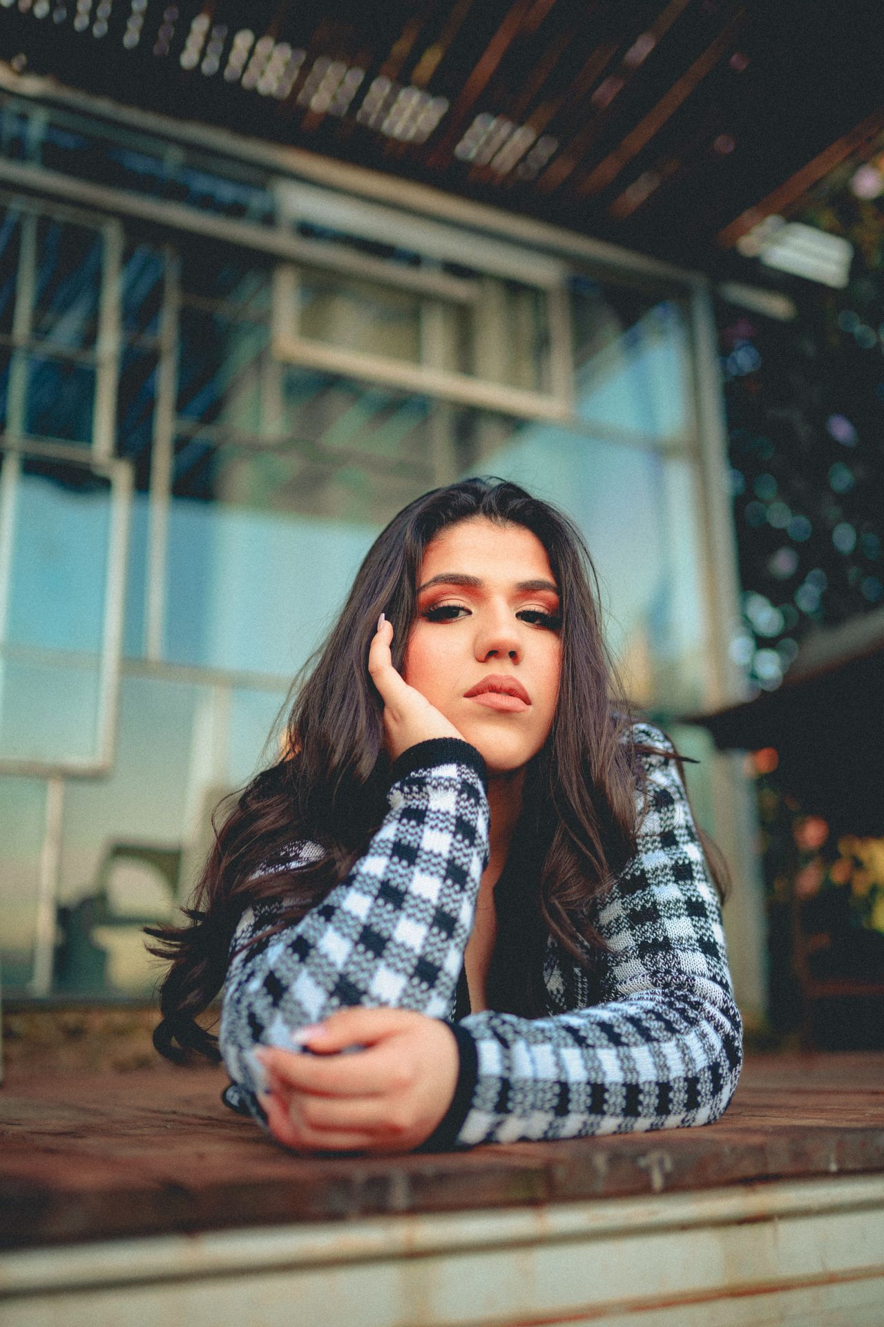 Woman wearing a black and white check knit cardigan open over a black top