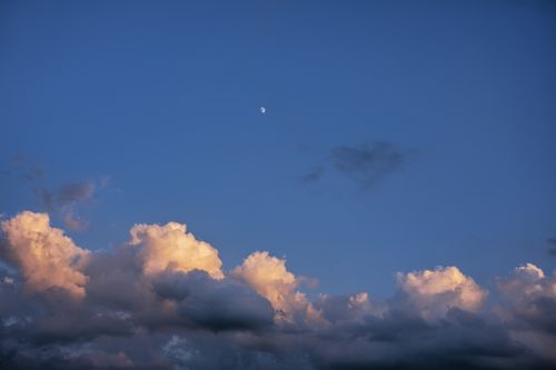 Free A tranquil sky in Nelson, WI, with clouds illuminated by sunset light and moon visible. Stock Photo