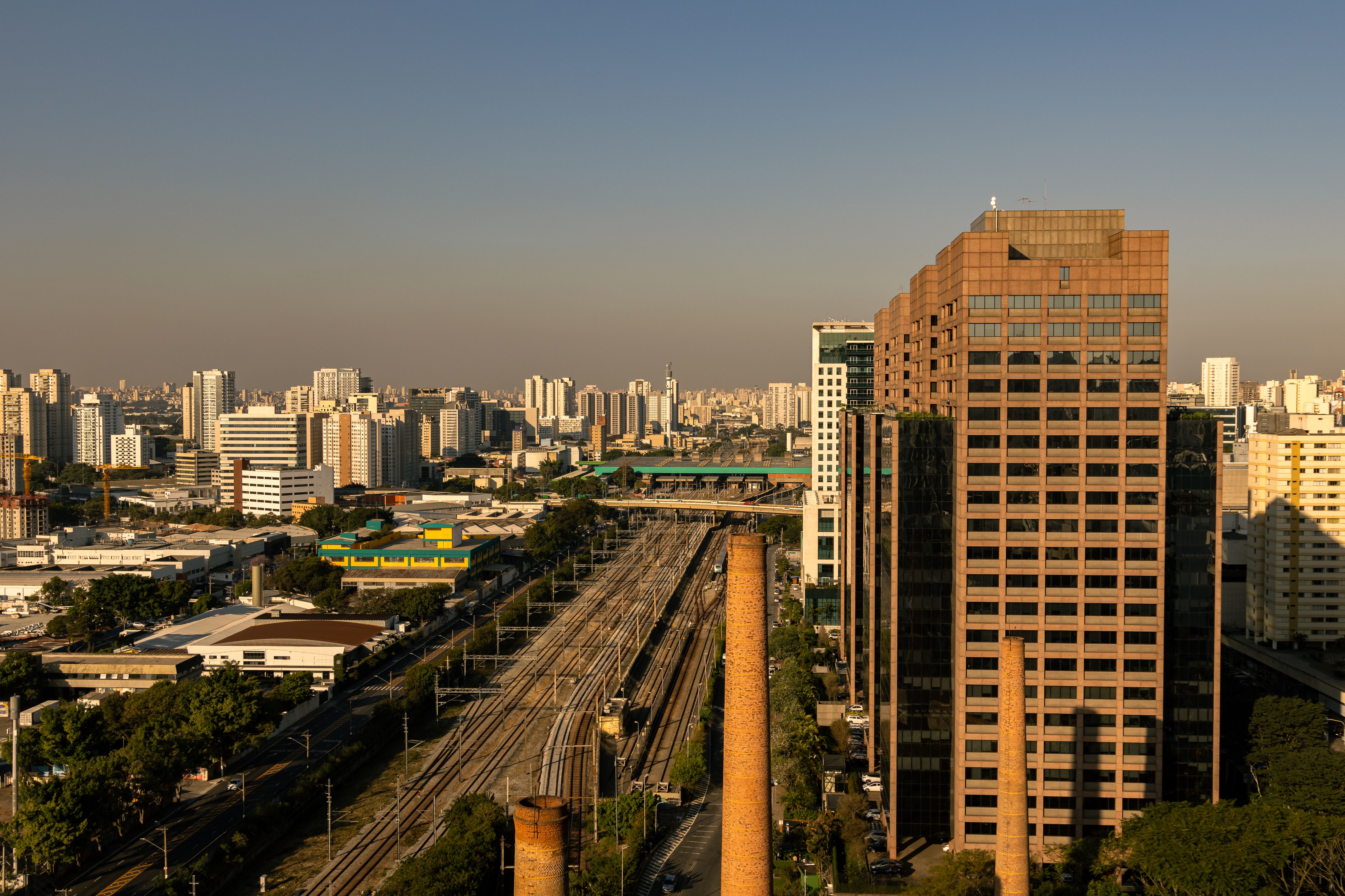 A city skyline with tall buildings and a train track · Free Stock Photo