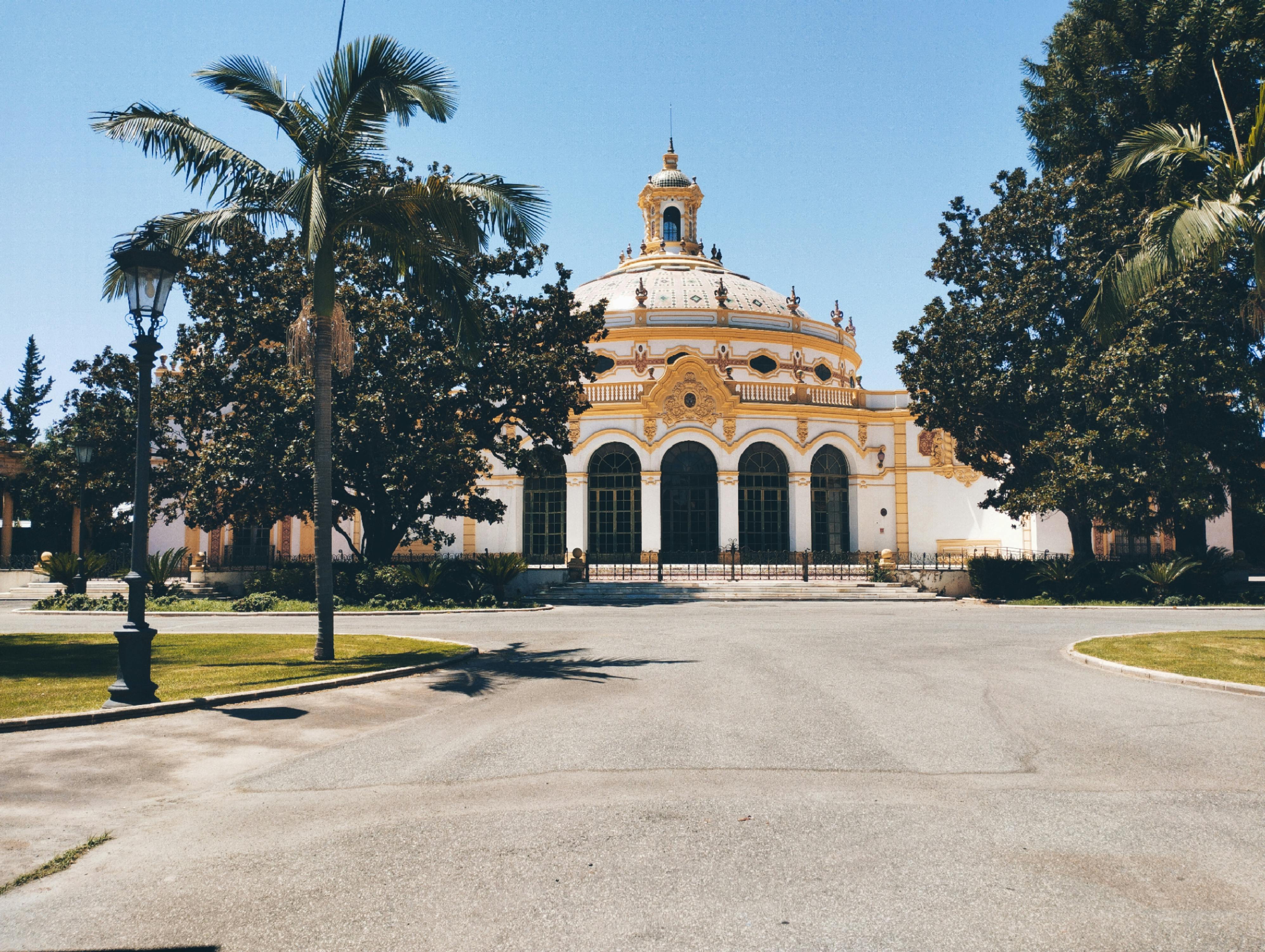 a large building with a dome and palm trees