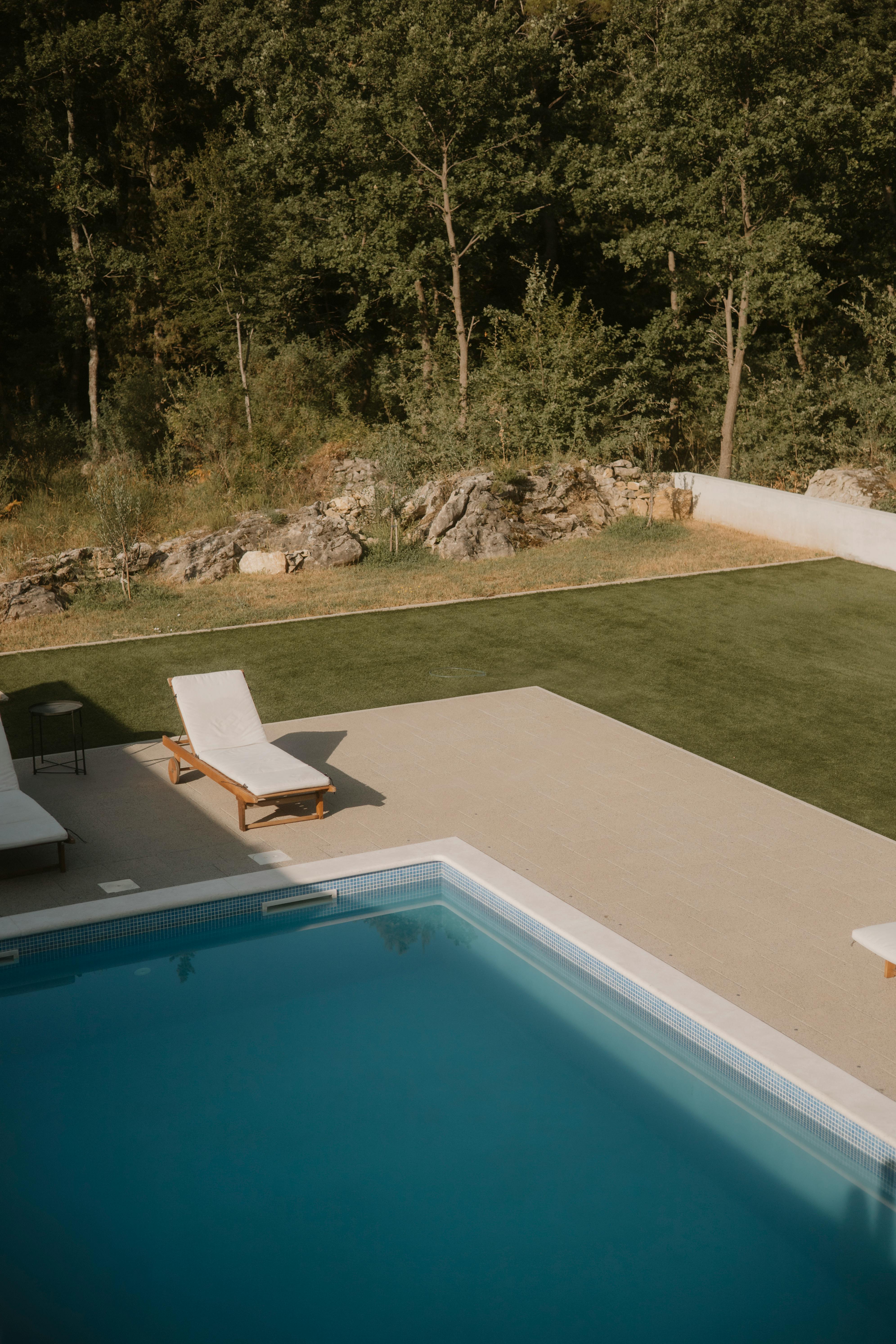 sun loungers by the pool near the forest