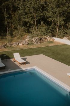 Peaceful outdoor pool area with sun loungers overlooking greenery in Omiš, Croatia.