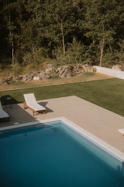 Peaceful outdoor pool area with sun loungers overlooking greenery in Omiš, Croatia.