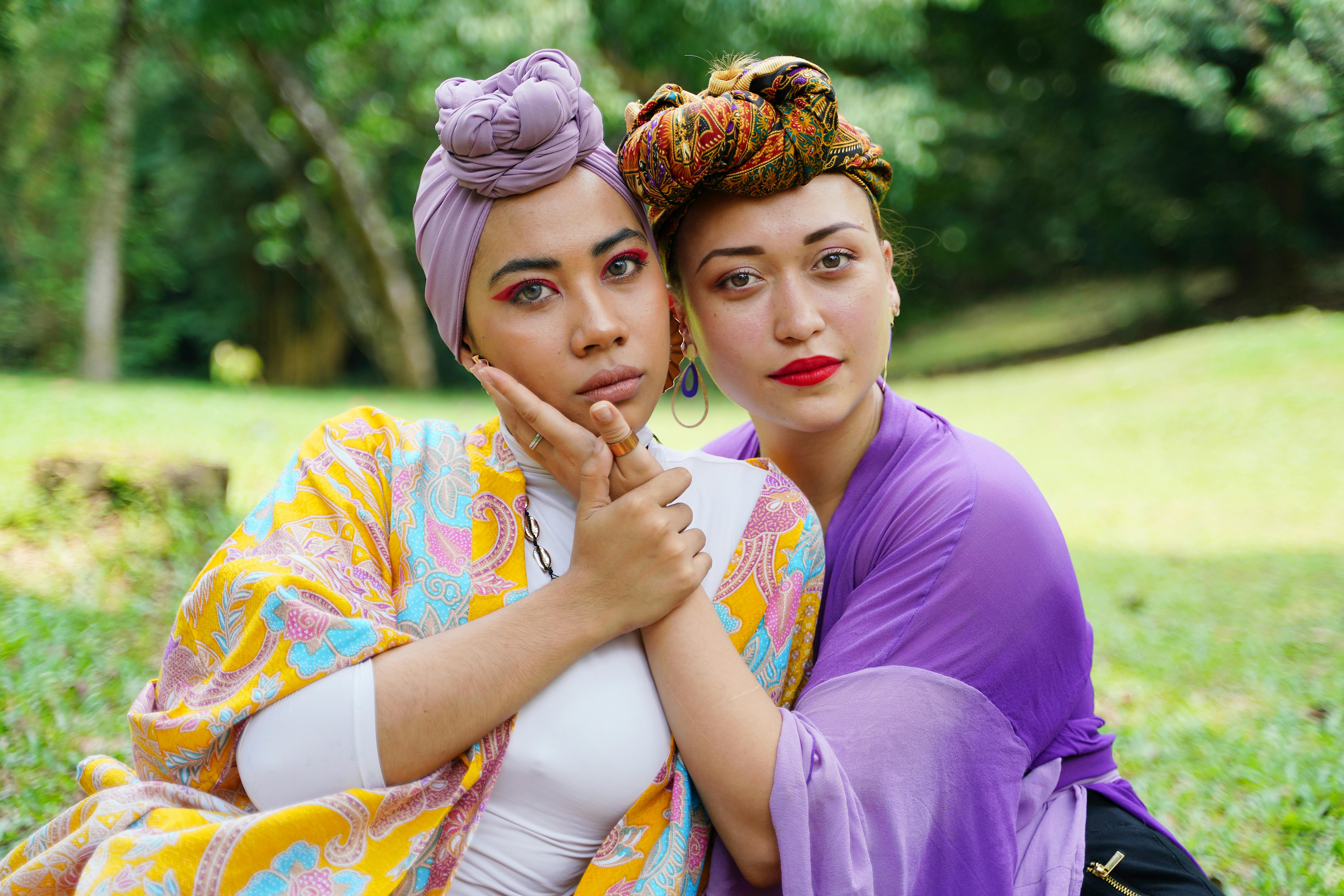 这幅户外肖像色彩缤纷，描绘了两位头戴时尚头巾、气质各异的女性，散发着友谊与优雅的气息