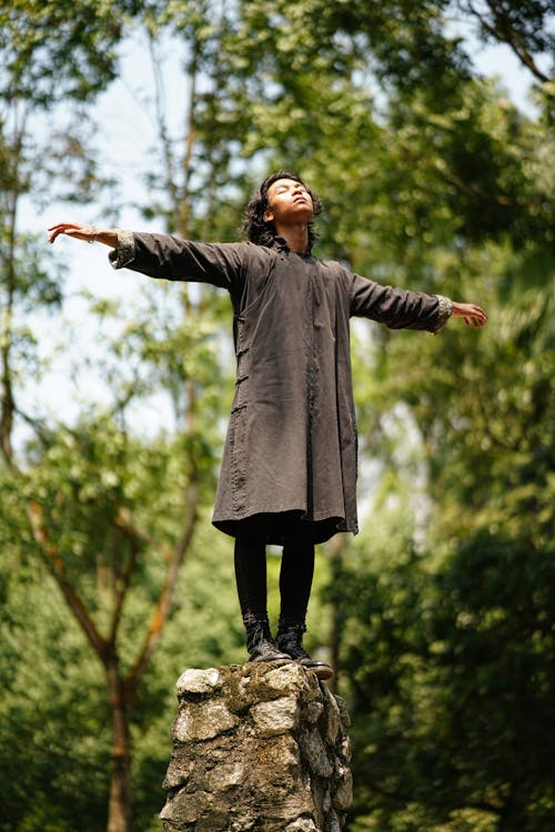 Man Standing on Stone While Spreading His Arms