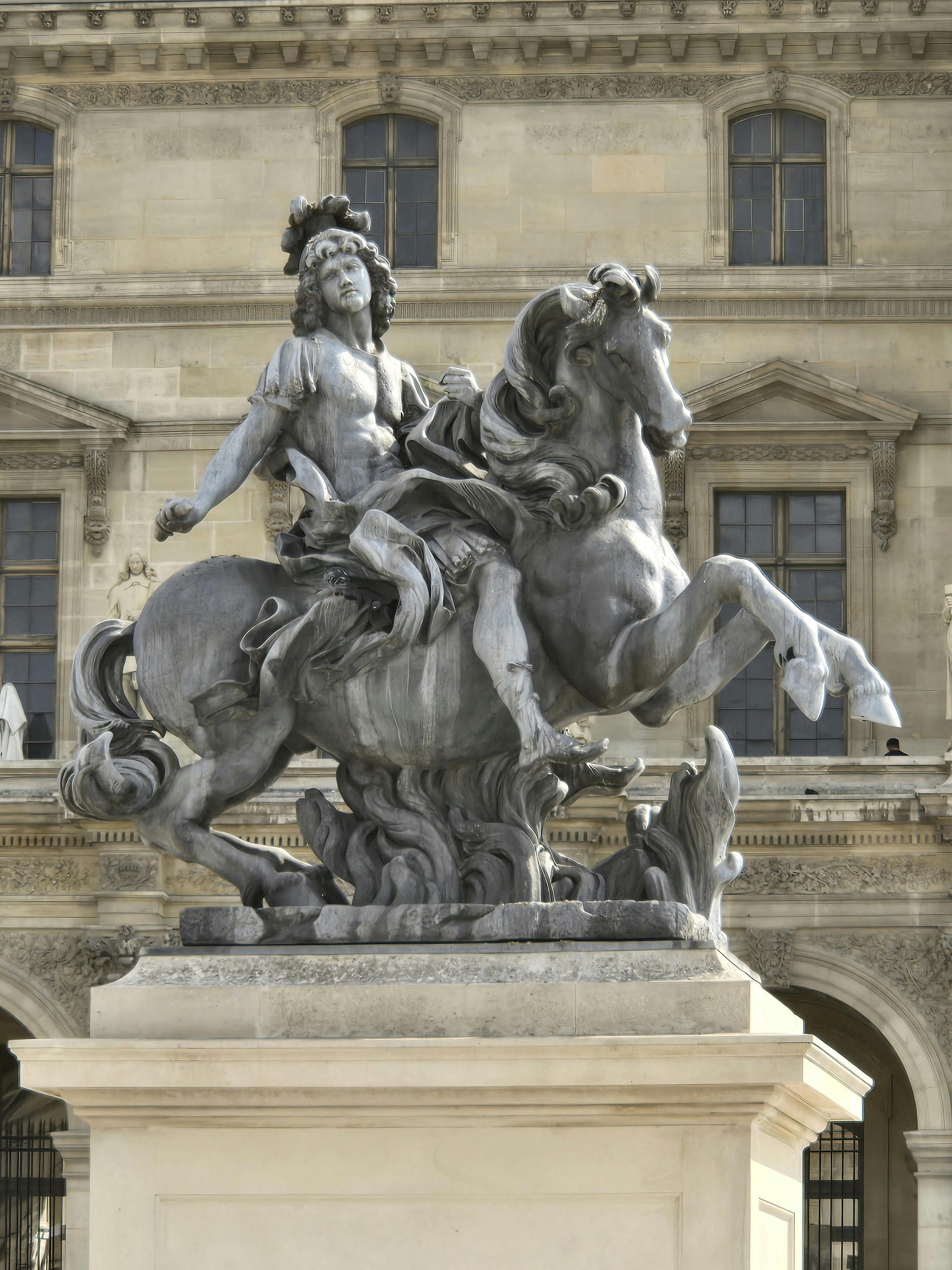 a statue of a man riding a horse in front of a building