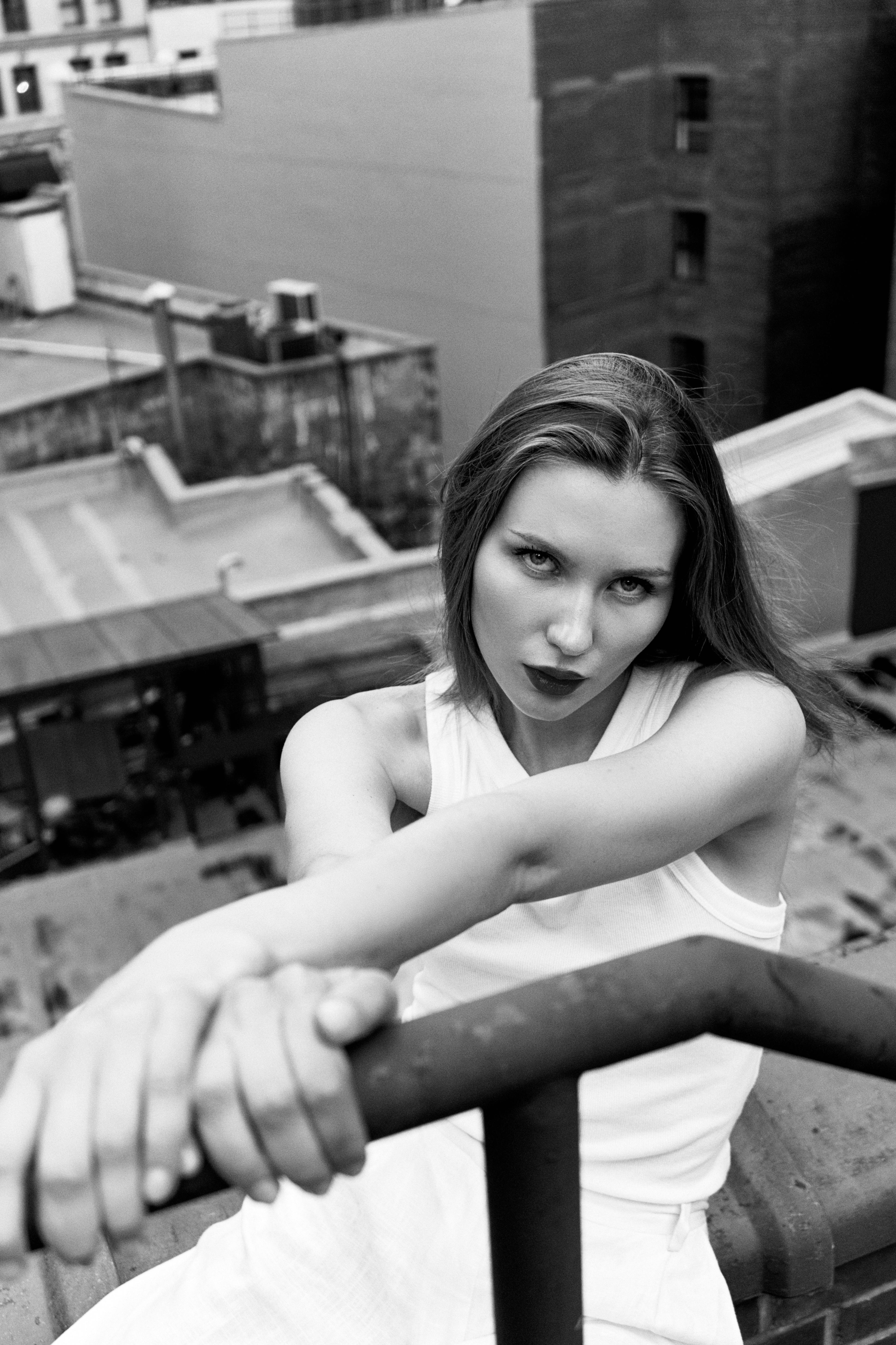 a woman in a white dress leaning on a railing