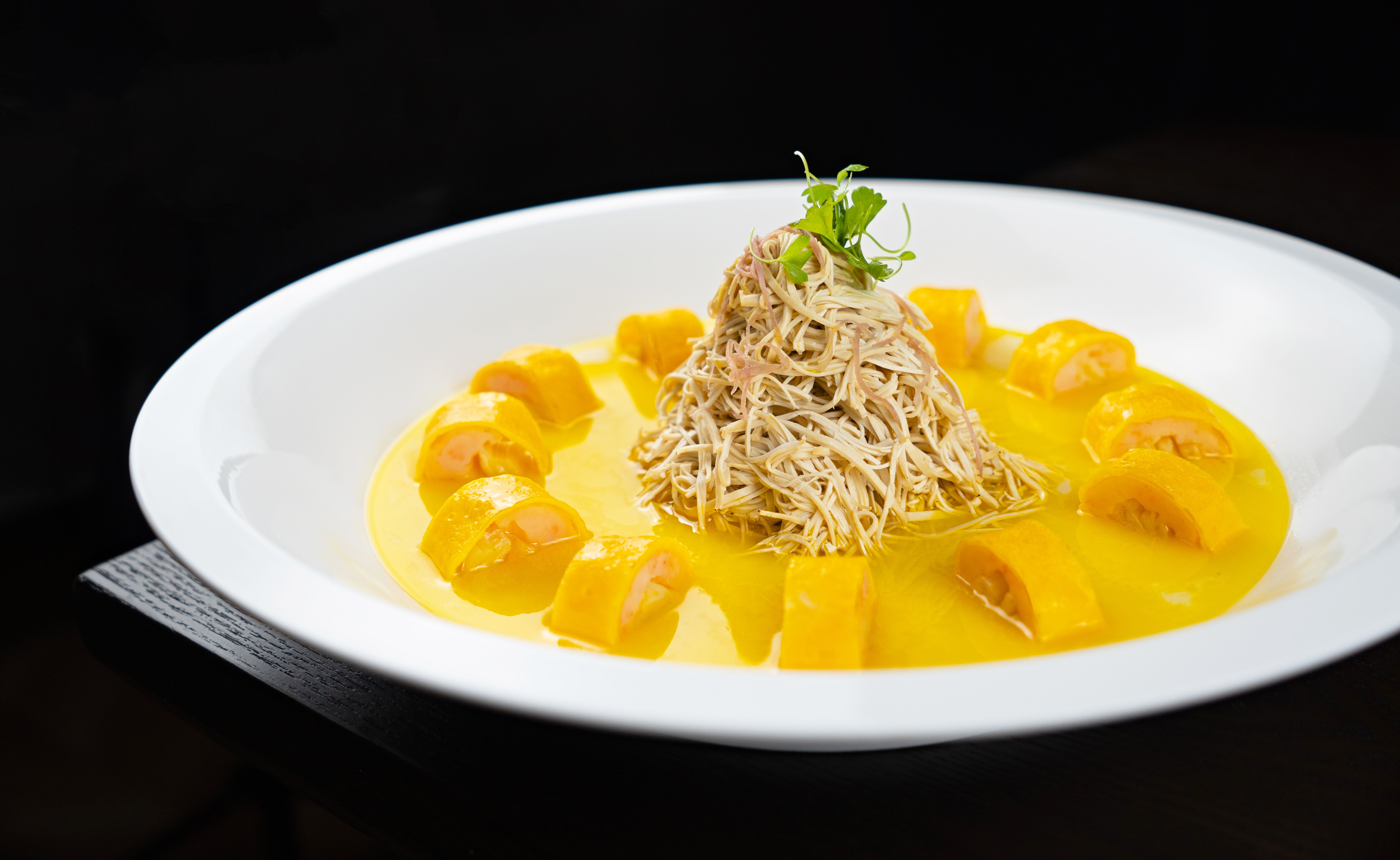 Delicious pasta served with creamy mango sauce and artistic garnishing.
