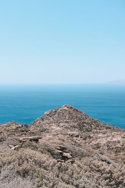 Experience the stunning coastal landscape of Fira, Greece, with rocky hills and expansive blue sea.