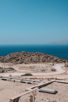 Explore the stunning coastal landscape of Fira, Greece with clear blue skies and rocky terrain.