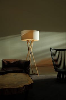 A cozy indoor setting featuring a modern floor lamp, stylish sofa, and designer chairs in warm lighting.