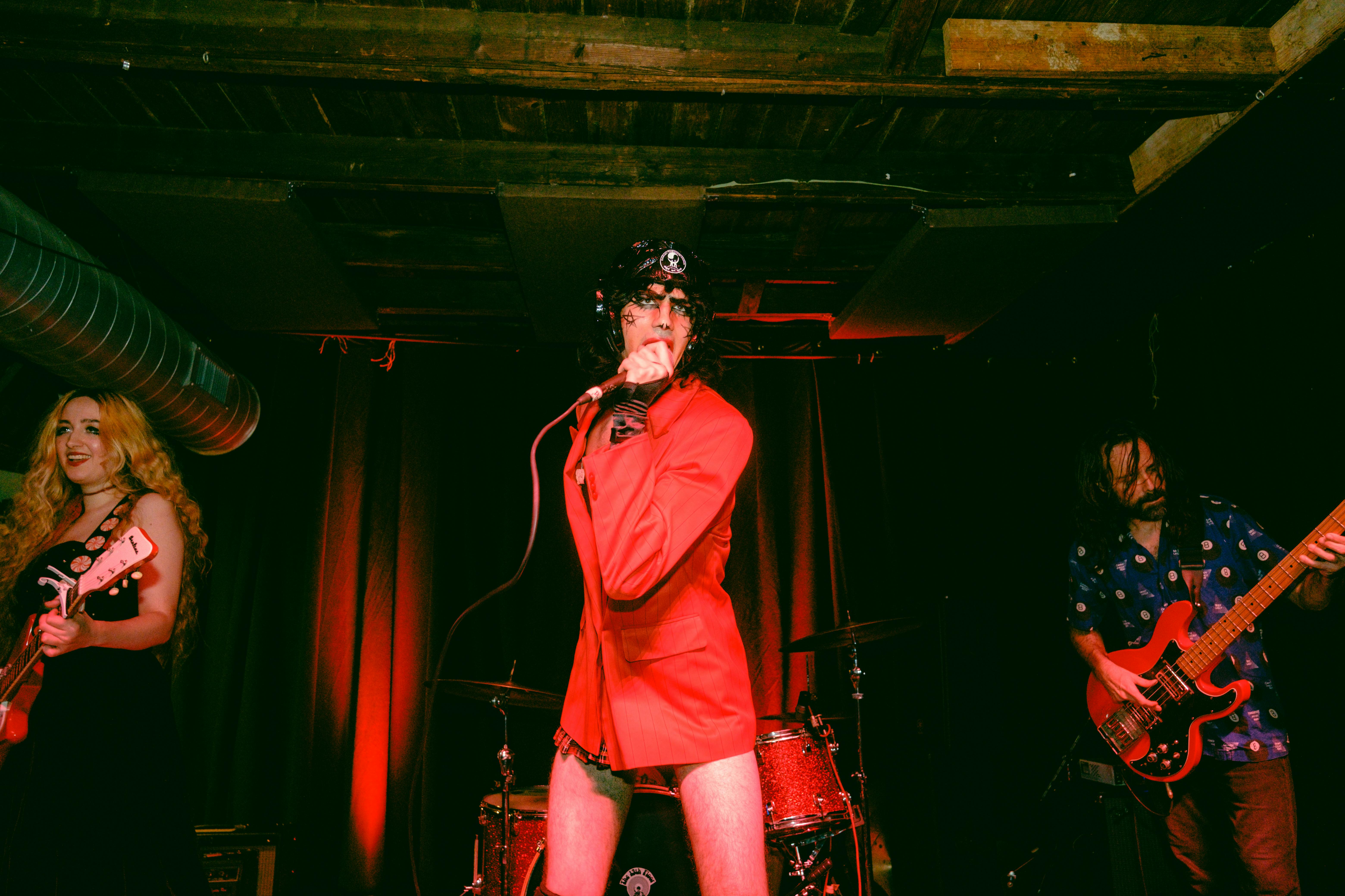 a woman in red outfit singing on stage