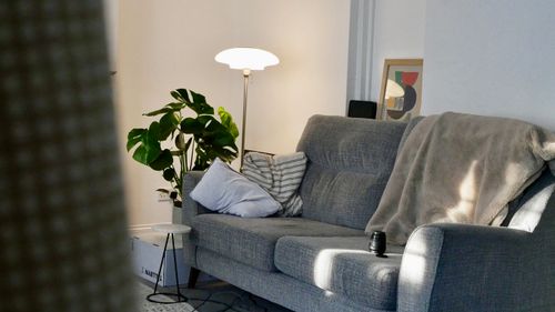 Living room with a grey sofa and floor lamp — photo by Stephen on Pexels