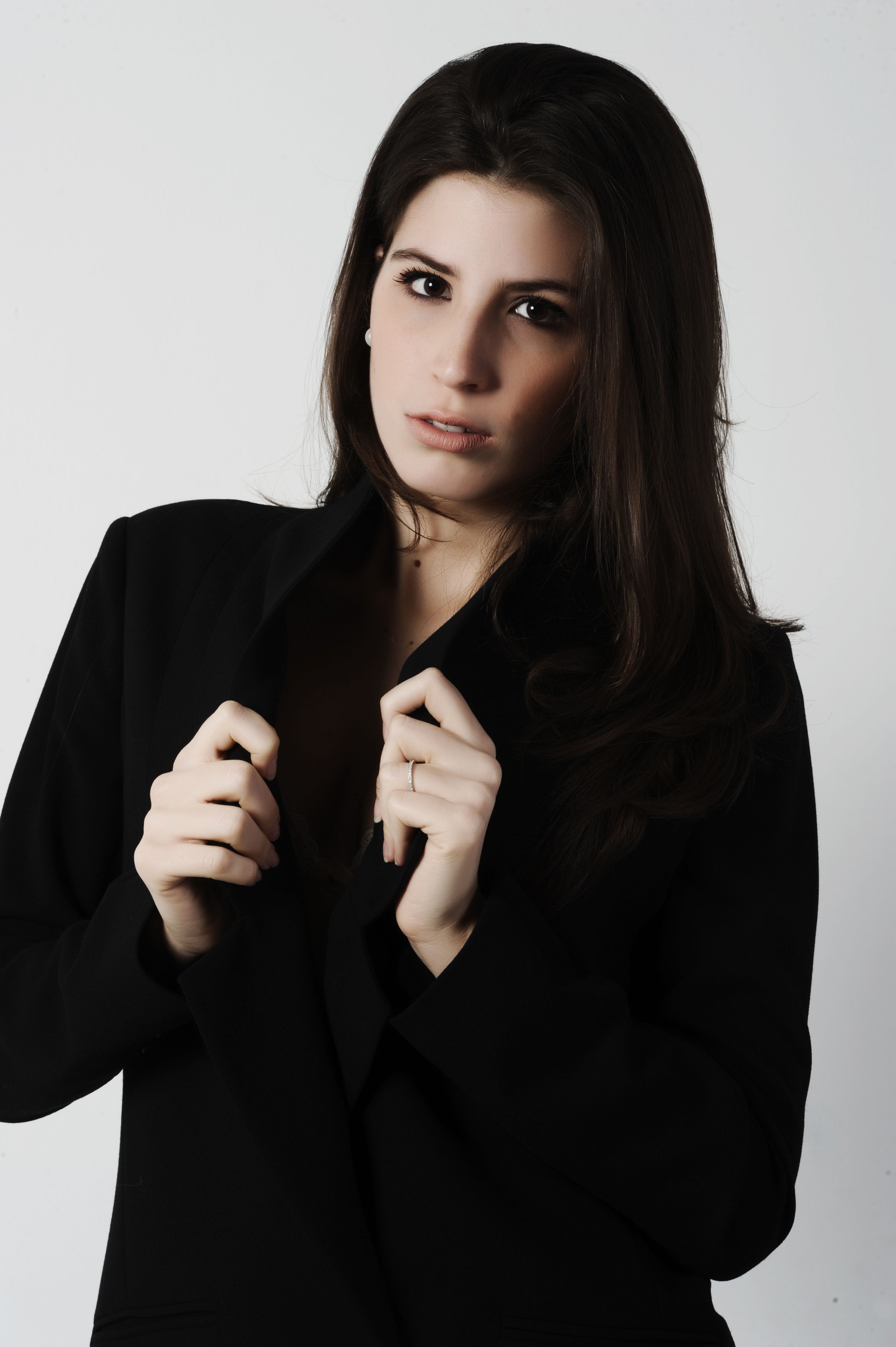 Chic portrait of a young brunette woman in a stylish black blazer exuding confidence and elegance.