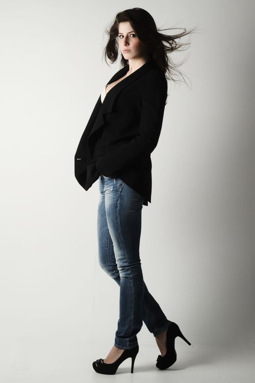 Free Trendy young woman posing in a blazer and jeans in a modern fashion portrait. Stock Photo