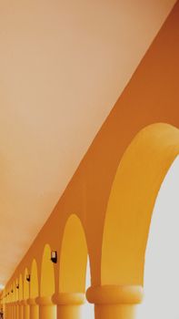 Bright yellow arches forming a corridor with artistic geometric lines, embodying a modern and vibrant architectural style.