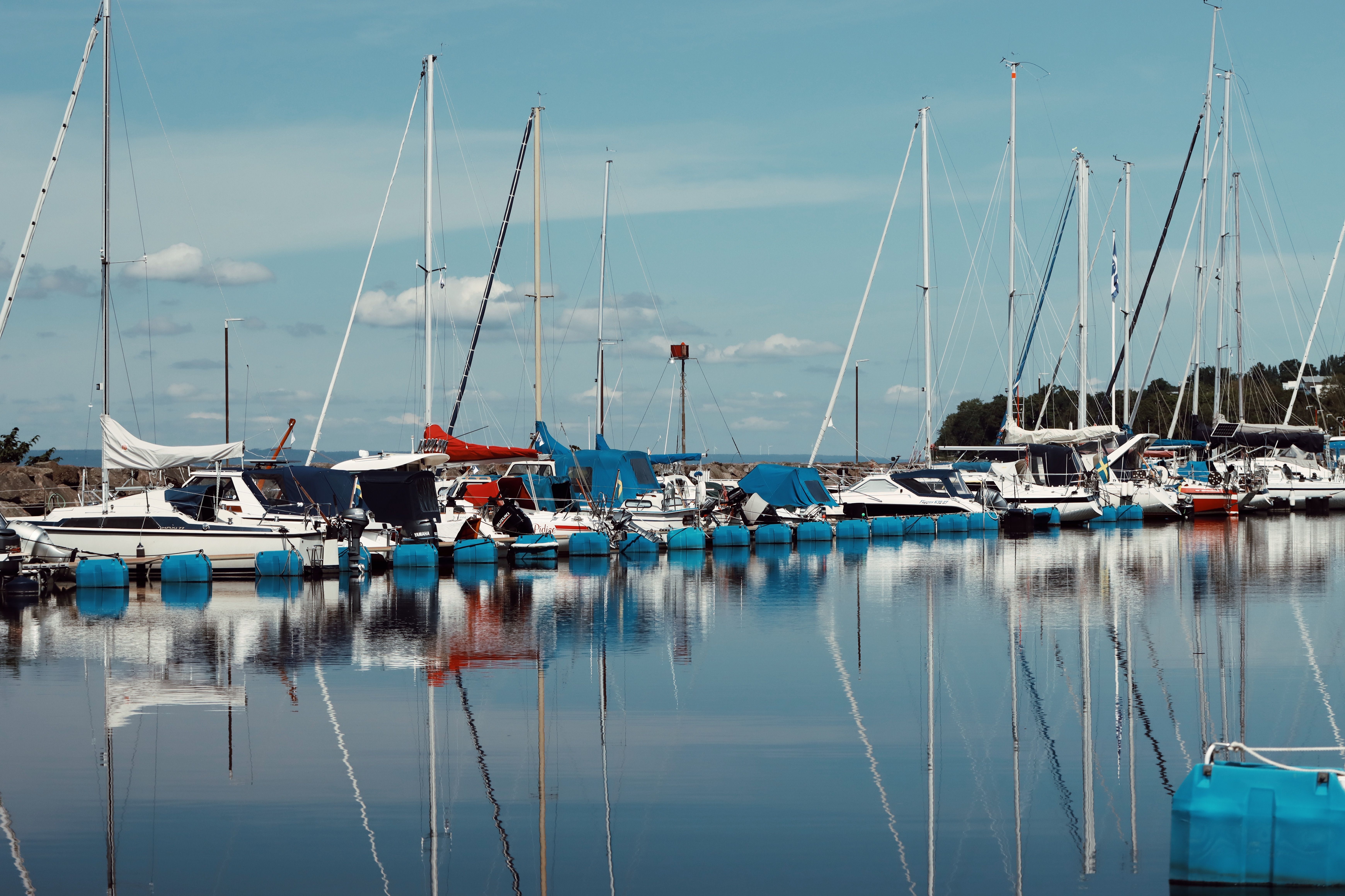 A serene view of sailboats docked at the picturesque Huskvarna harbor in Sweden.