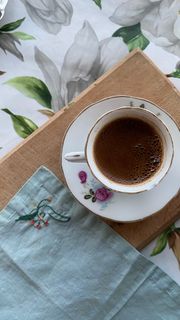 Coffee cup on an embroidered cloth, photo by Esra Karakulak on Pexels