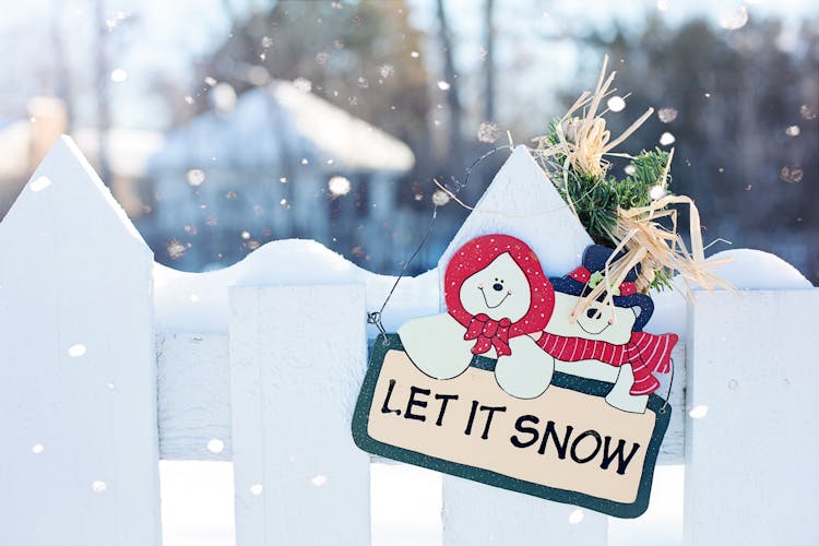 Let It Snow Signage Hanging On Fence