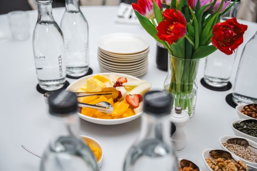 An elegant dining setup featuring fresh fruits and vibrant tulips, perfect for a healthy meal.