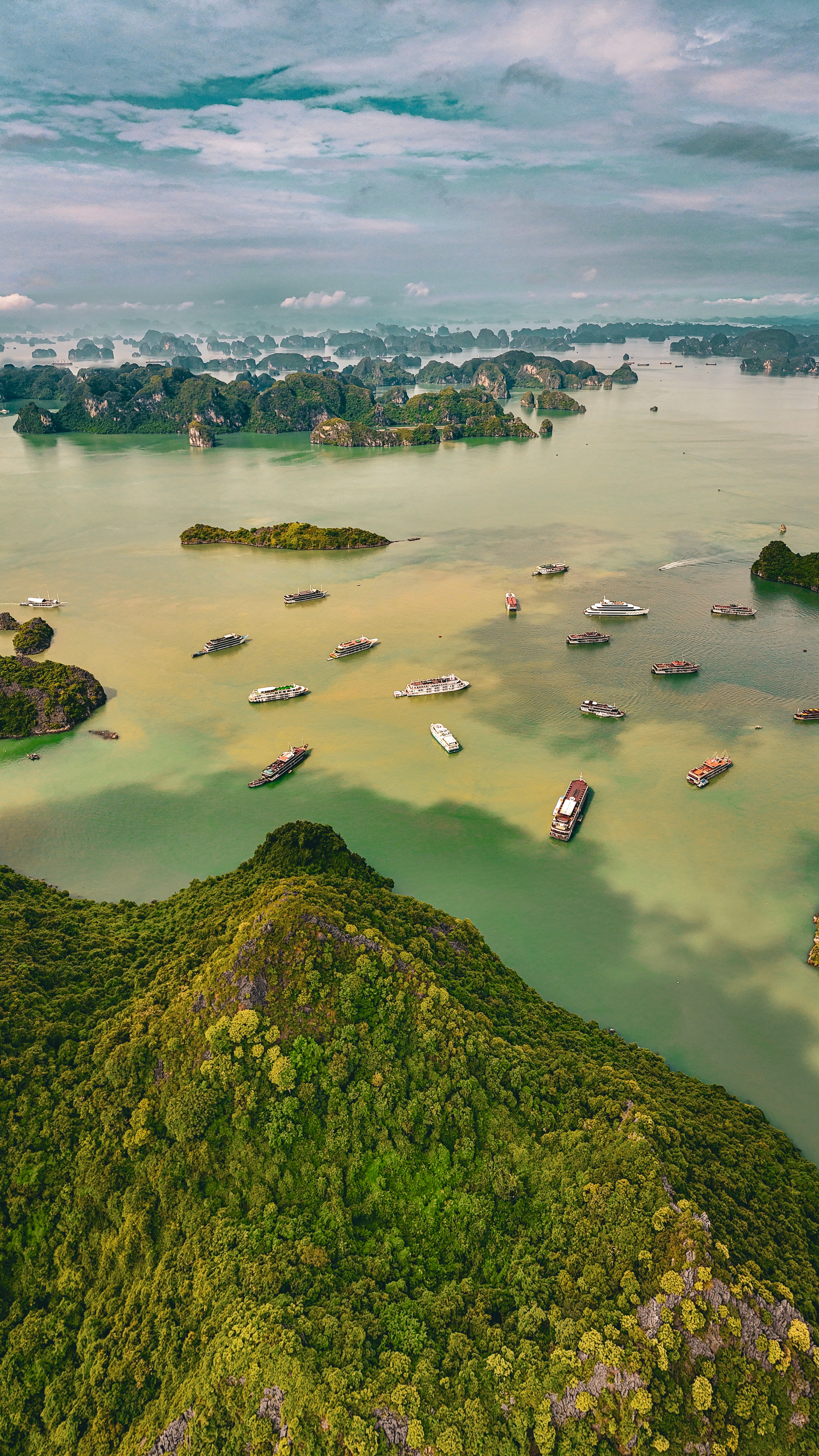 A stunning aerial view of Ha Long Bay in Vietnam with lush green islands and boats.