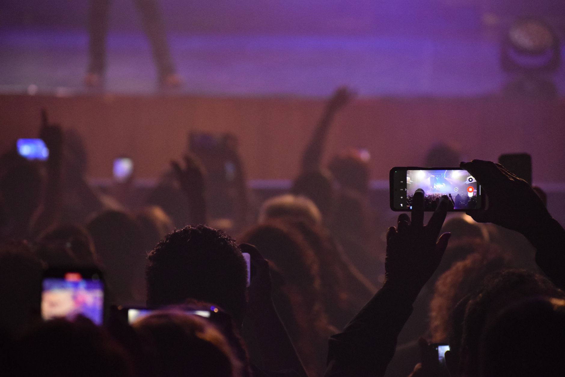 Audience capturing live music performance with phones at night concert in San Luis, Argentina.