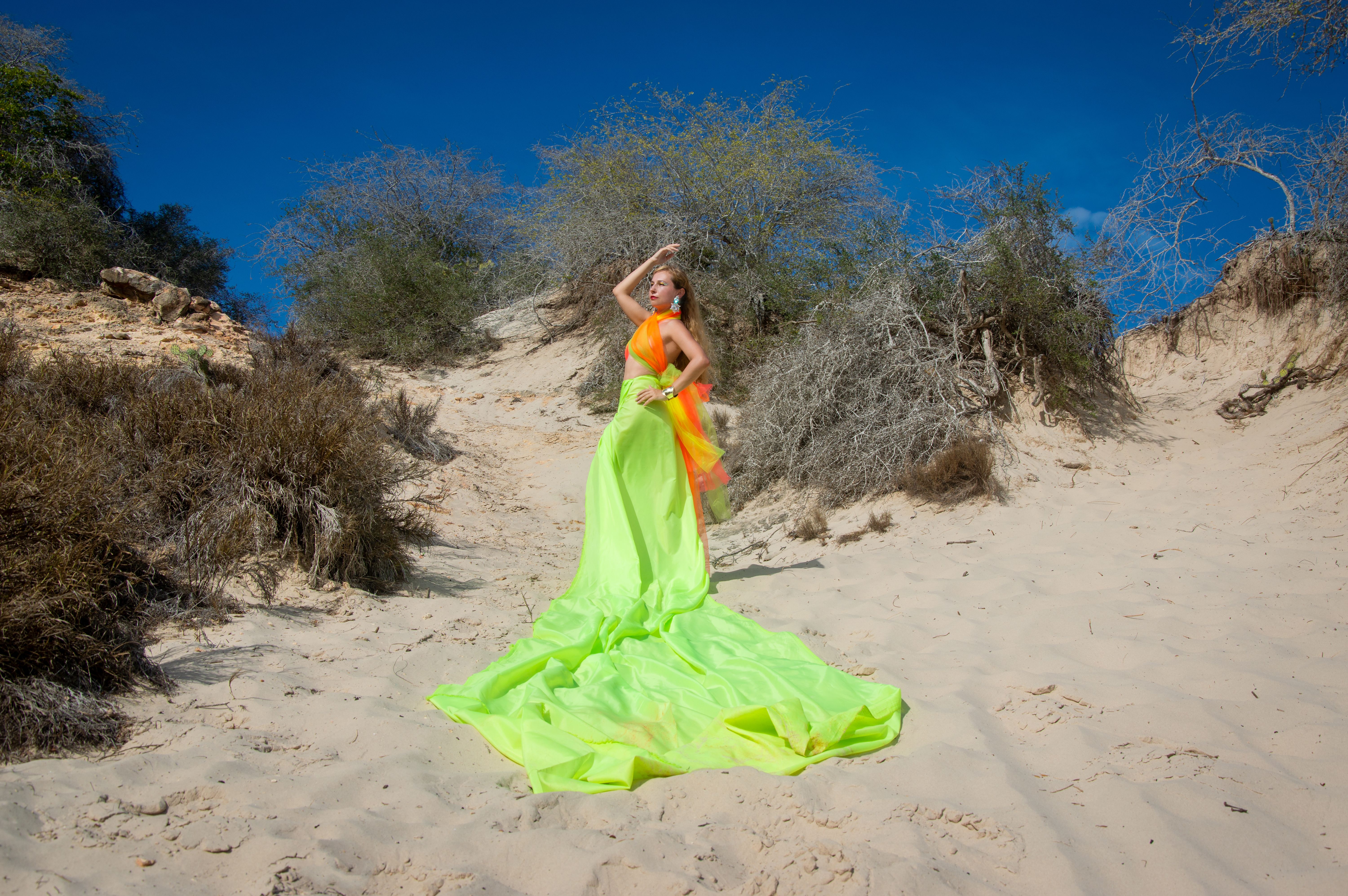 Woman in neon green dress on beach dunes