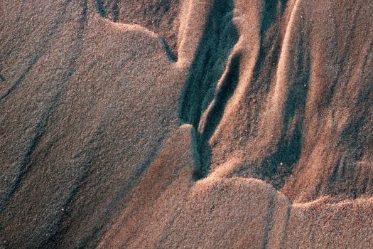 Close-up of textured sand patterns on Guaratuba beach, showcasing natural formations and earthy colors.