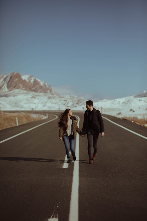 Free Man and Woman Walking on Road Stock Photo