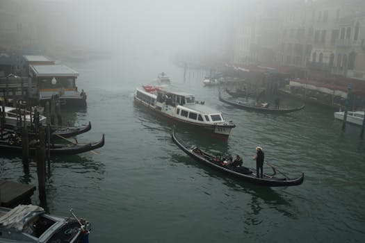 Scenic view of a foggy Venice canal with gondolas and boats, capturing the essence of the city's waterways.